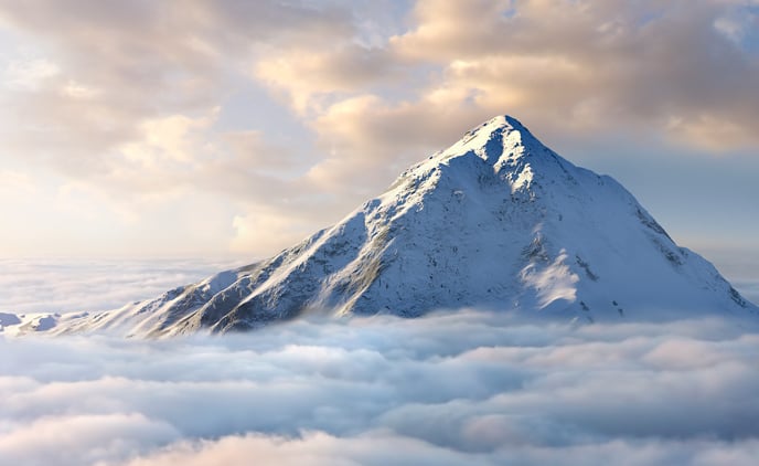 photo of a mountain rising above clouds